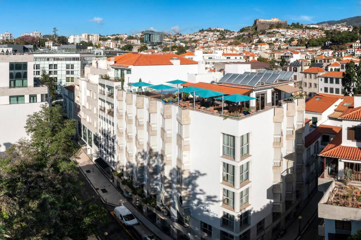 Vista aérea do hotel Madeira, no Funchal, com esplanada e piscina no topo do edifício.