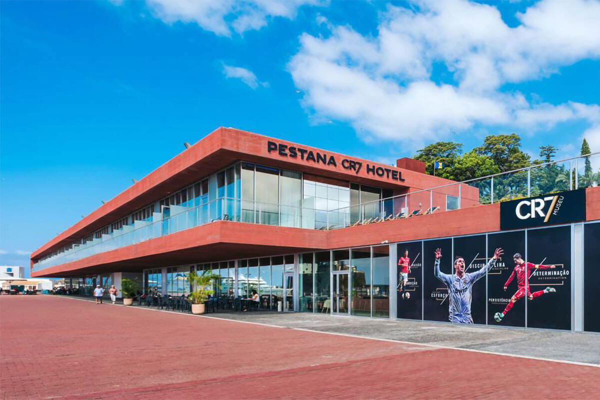 Fachada frontal e lateral do Hotel Pestana CR7 com imagens do jogador de futebol Cristiano Ronaldo no edifício do Museu CR7.